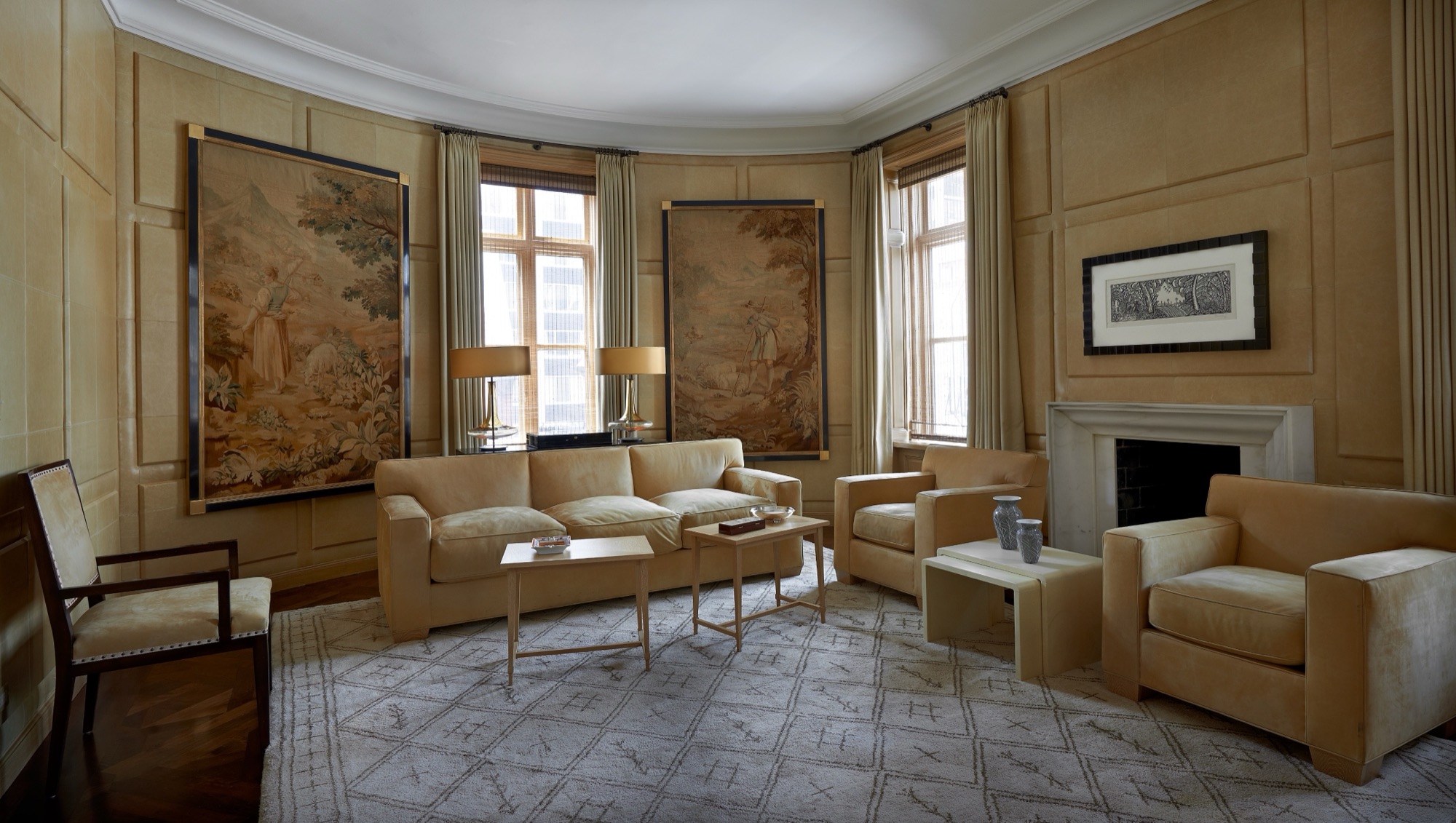 A warm, vellum-paneled living room with antique tapestries, an interior by Scott Himmel & Co.